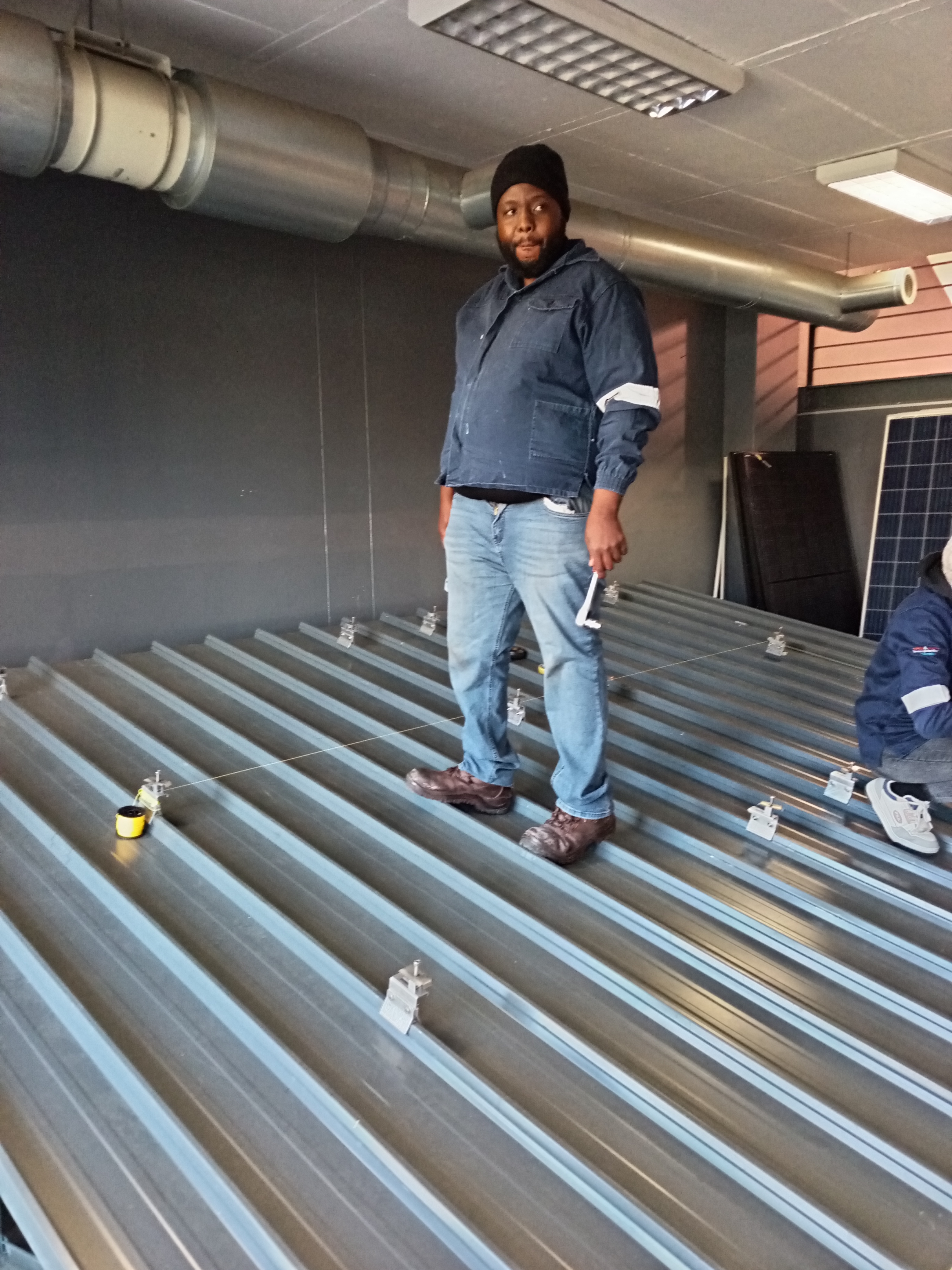 a worker on top of a roof installing solar panels